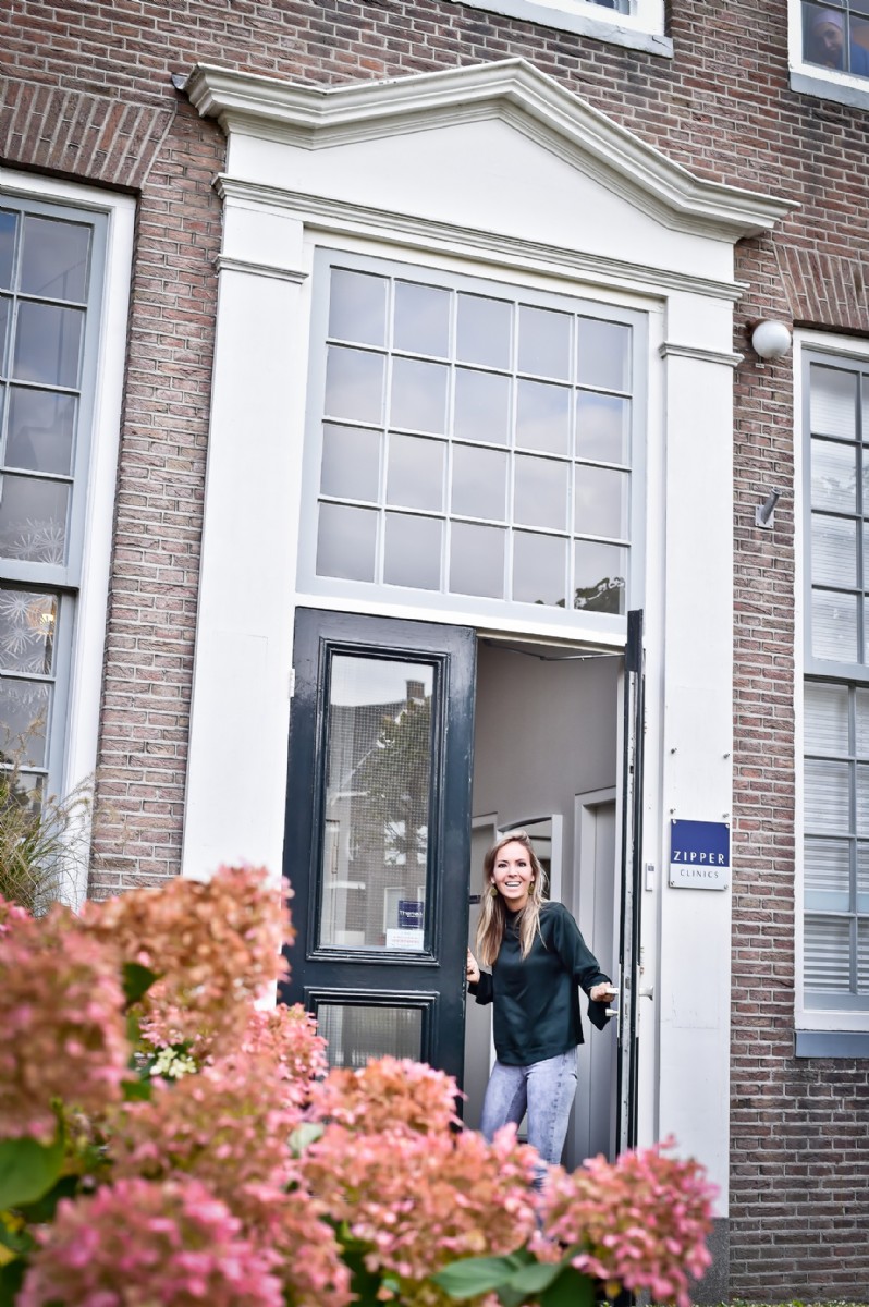 Floortje Zipper vor dem Eingang der Zipper Clinics Enschede